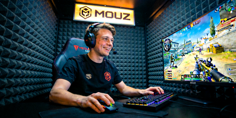 MOUZ NXT战队选手在隔音房内专注操作，屏幕显示CS2游戏画面